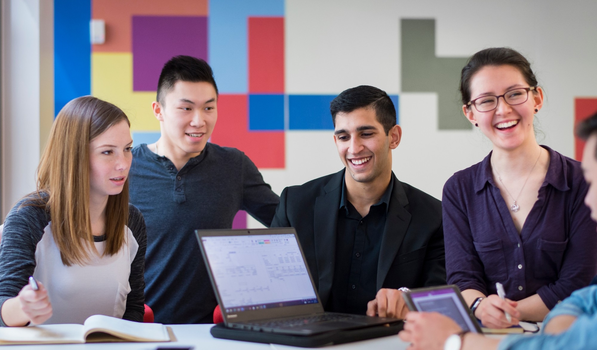 Students in a group using a laptop