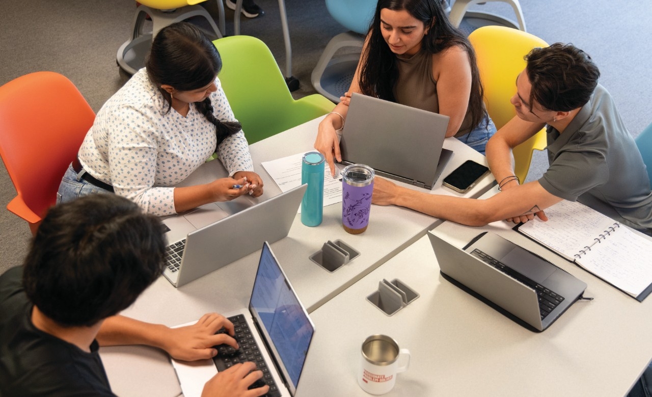 Students in a group using a laptop